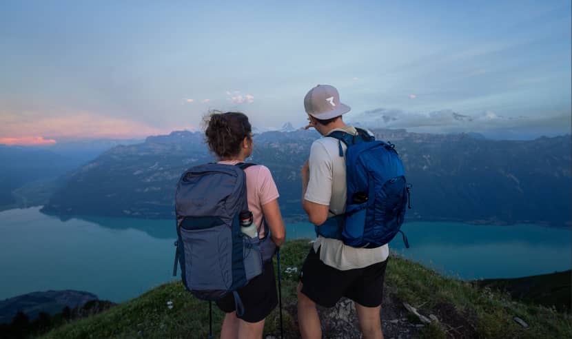 Escursionisti con zaini Osprey che dominano il lago di montagna