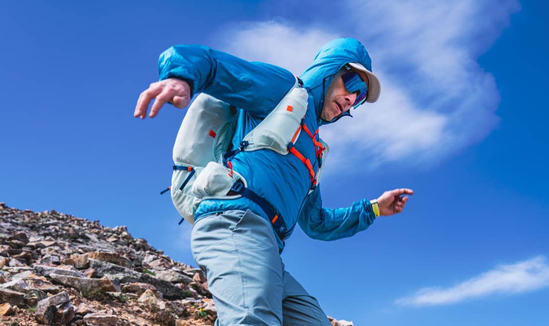 Corridore da trail che scende su un sentiero di montagna rocciosa