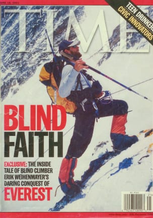 Die Titelseite des TIME Magazine. Das Foto zeigt Erik Weihenmayer in einem langärmeligen T-Shirt, einer Baseballmütze und Expeditionsschneestiefeln. Er steht an einem steilen, schneebedeckten Hang, trägt einen gelben Osprey Aether 60 und hält einen Wanderstock in seiner rechten Hand. Er ist mit einem Klettergurt, einem Seil und einem Karabiner an einem festen Seil gesichert. Die Überschrift lautet: „BLIND FAITH. Exklusiv: Der Insiderbericht des blinden Kletterers Erik Weihenmayer über seine kühne Eroberung des EVEREST.“
