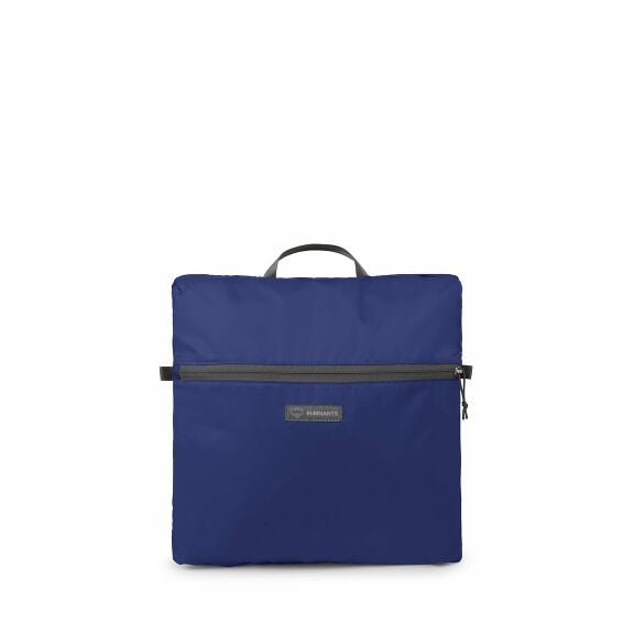 The images show a compact, foldable backpack in a deep blue color. The backpack features a zipper along the top edge, which allows it to open and close. There is a small handle on top for easy carrying when it's folded. It has a front pocket with a zipper