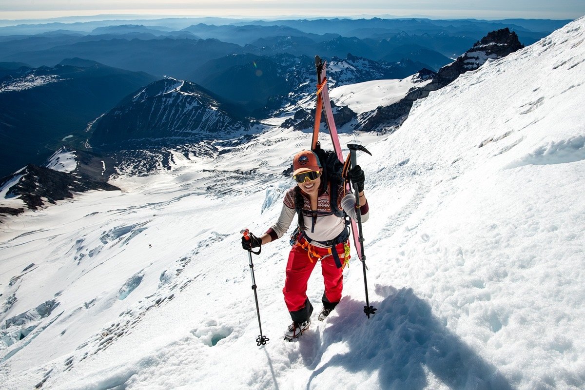 A woman touring up a snowy mountain in ski gear