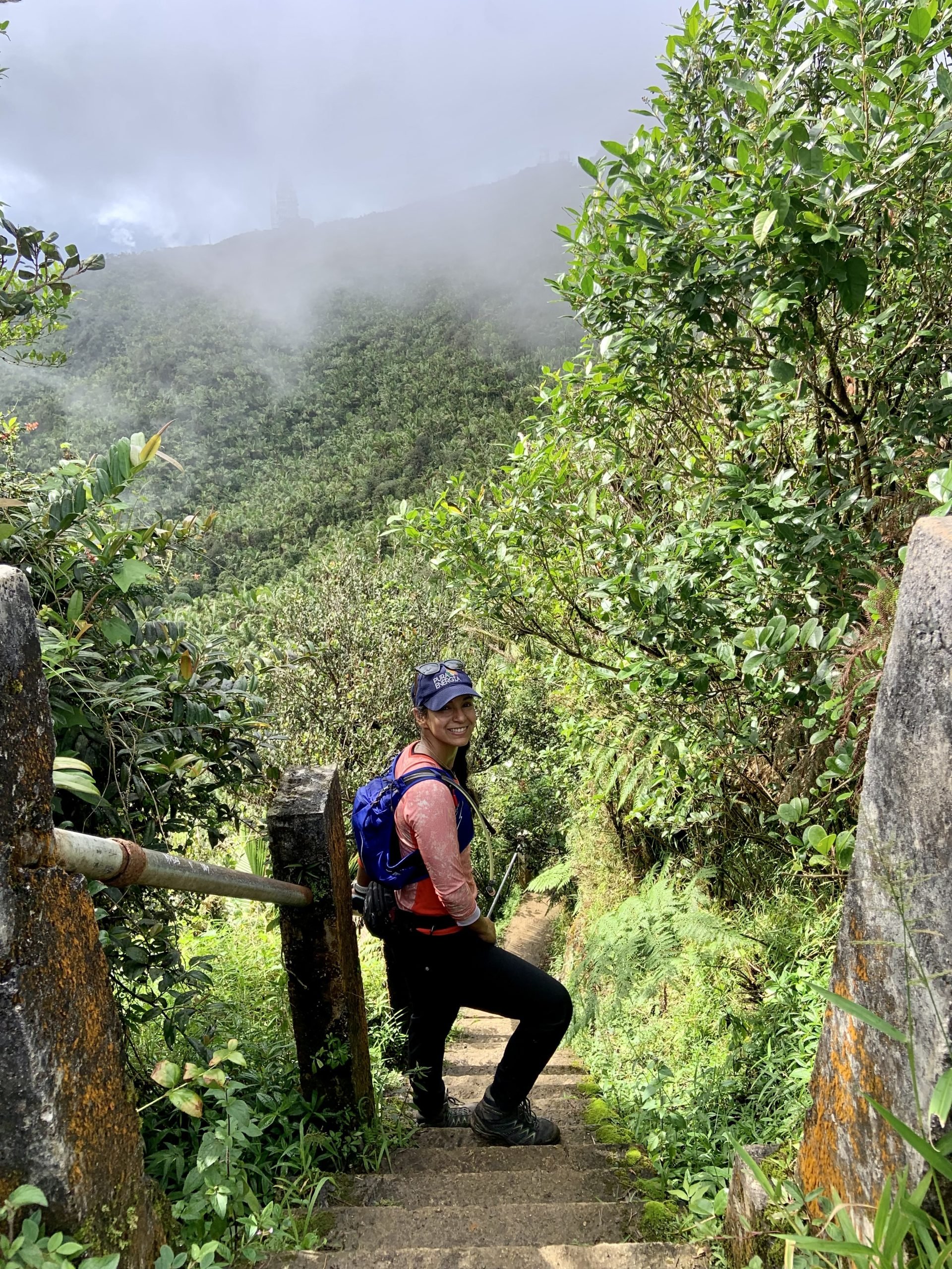 A women in running gear standing on a set of stairs along the Veredas Noreste trail